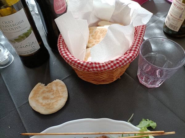 Cestino di tigelle coperto dal tovagliolo, sul tavolo apparecchiato